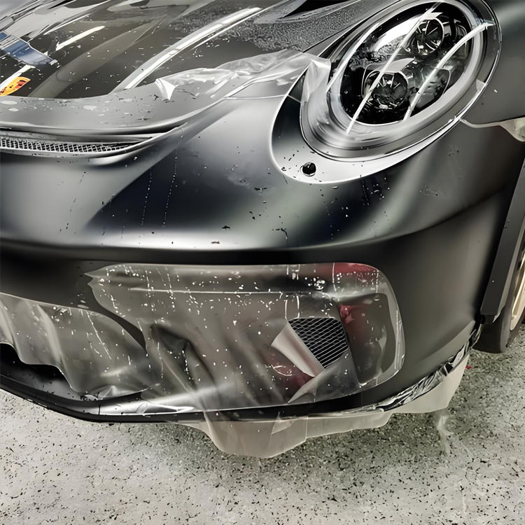 Paint protection film being installed over a headlight and front bumper